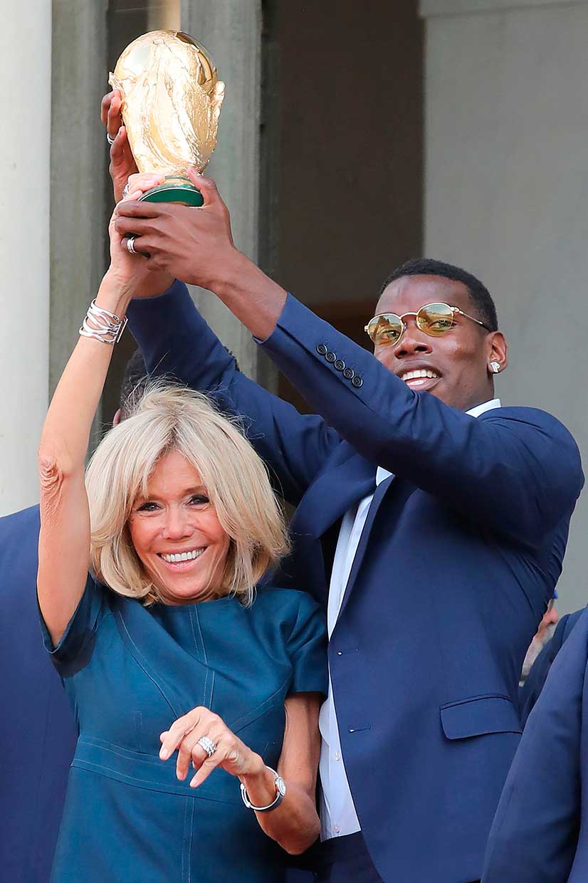 Ibu Negara Brigitte Macron mengangkat trofi Jules Rimet bersama gelandang Prancis Paul Pogba.