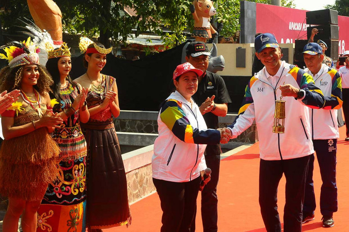 Menko PMK Puan Maharani (tengah) menyerahkan tinder box yang berisi api kepada Gubernur Jawa Tengah Ganjar Pranowo. Api yang menjadi perwakilan api abadi dari seluruh wilayah di Indonesia tersebut akan disatukan dengan api asal India di Prambanan, Yogyakarta, Rabu malam. Api asal India telah tiba pada Selasa, 17 Juli 2018.