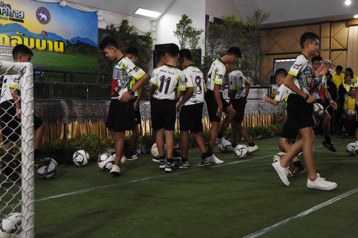 Remaja berusia 11 hingga 16 tahun dan pelatih mereka yang berusia 25 tahun, kompak mengenakan kaus oblong bergambar babi merah liar, serta membawa bola kaki yang mereka tendang dengan pelan di tempat tersebut. Mereka disambut oleh dokter, kerabat dan teman.