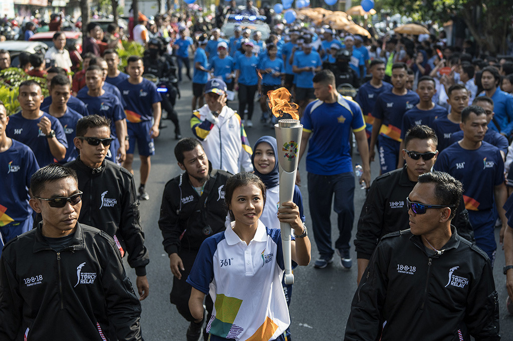 Atlet lari paragames (disabilitas) Nanda Mei Sholihah membawa obor saat prosesi Torch Relay Asian Games 2018 melintasi kawasan Jalan Brigjen Katamso, Yogyakarta, DI Yogyakarta.
