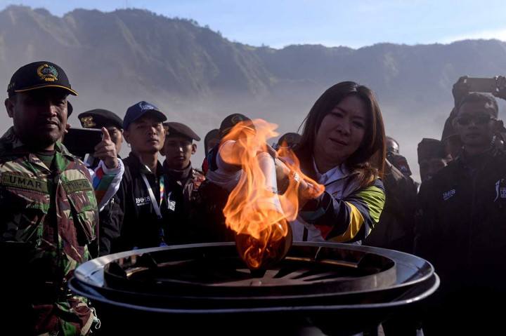 Lagenda bulu tangkis Indonesia Susi Susanti menyalakan mini kaldron di dekat sebuah pura dengan obor Asian 2018 saat prosesi Torch Relay Asian Games 2018 di lautan pasir Gunung Bromo, Probolinggo, Jawa Timur.