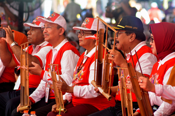 Menteri Pemberdayaan Perempuan dan Perlindungan Anak Yohana Susana Yembise (tengah) Gubernur Jawa Timur Soekarwo (kedua kanan) memainkan alat musik angklung saat puncak peringatan Hari Anak Nasional 2018 di Kebun Raya Purwodadi, Pasuruan, Jawa Timur. Antara Foto/Umarul Faruq