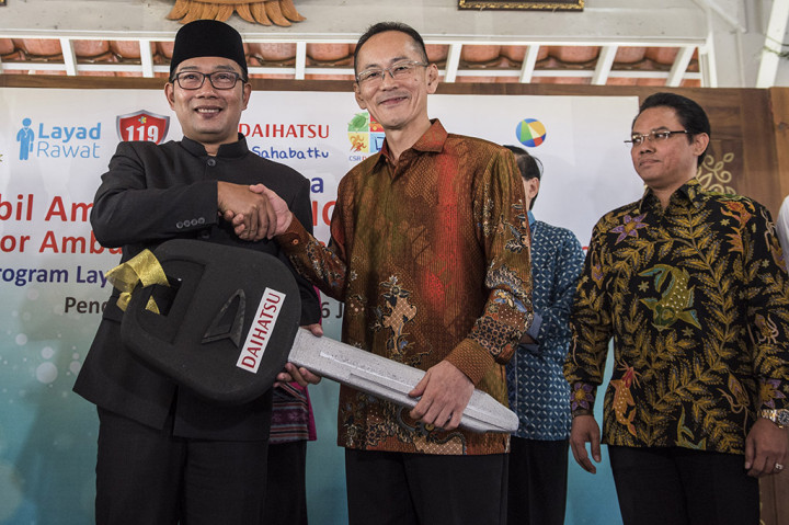 Direktur PT Astra Daihatsu Motor Shinya Takeda (tengah) menyerahkan secara simbolis kunci mobil kepada Walikota Bandung Ridwan Kamil (kiri) disaksikan Marketing dan CR Division Head PT Astra International Hendrayadi Lastiyoso (kanan) saat penyerahan bantuan CSR Daihatsu di Pendopo Kota Bandung, Jawa Barat. Momen tersebut berbarengan dengan satu tahun beroperasinya program Layad Rawat yang digulirkan Pemkot Bandung. 