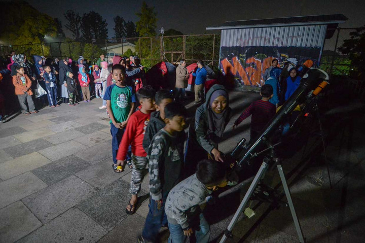 Sejumlah anak antre untuk mengamati gerhana bulan total dengan menggunakan teleskop di Lapangan Salman ITB, Bandung, Jawa Barat, Sabtu, 28 Juli 2018 dini hari.  Antara Foto/Raisan Al Farisi