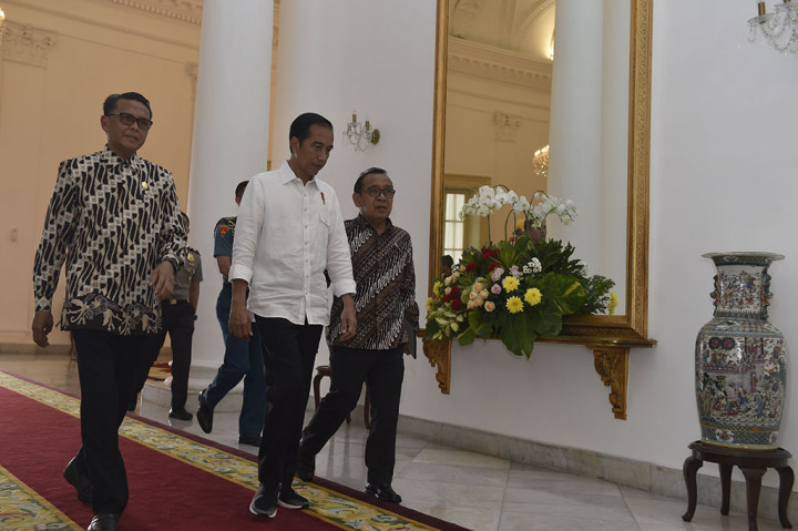 Presiden Joko Widodo (tengah) didampingi Mensesneg Pratikno (kanan) dan Bupati Bantaeng Nurdin Abdullah (kiri) berjalan menuju ruang Garuda untuk menerima sejumlah bupati dalam audiensi di Istana Bogor, Jawa Barat.