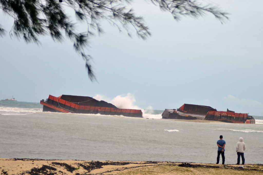 Sebuah kapal tongkang batu bara kandas dan patah menjadi dua akibat diterjang gelombang besar di perairan Pantai Ujung Kareng, Lhoknga, Aceh Besar, Minggu, 29 Juli 2018. 