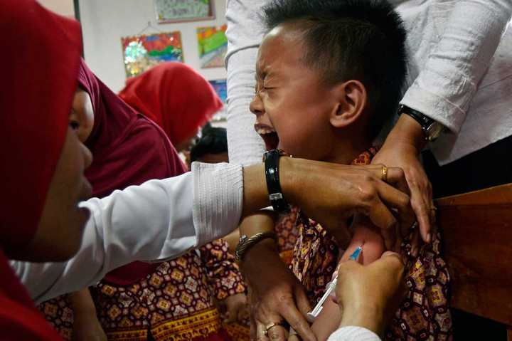Seorang pelajar meringis saat mendapat imunisasi MR di SD al-Kautsar Bandar Lampung, Lampung. Antara Foto/Ardiansyah