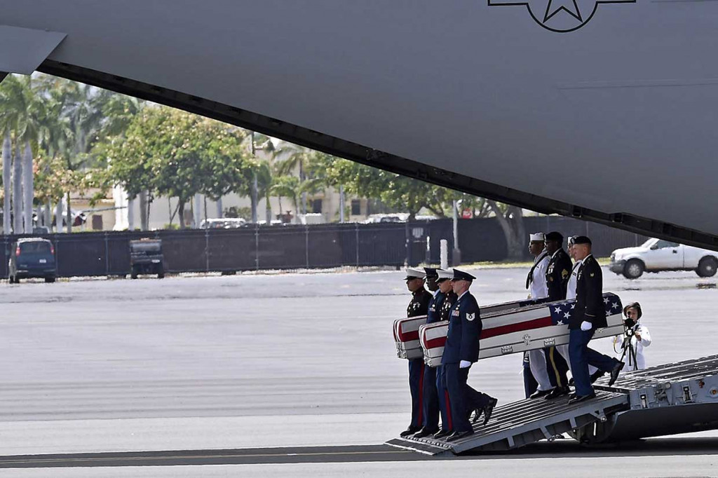 Satu-persatu peti mati berisi sisa-sisa kerangka yang diyakini tentara AS dibawa keluar dari pesawat setelah tiba di Pangkalan Udara Pearl Harbor-Hickam, Honolulu, Hawaii, Rabu, 1 Agustus 2018 waktu setempat. 