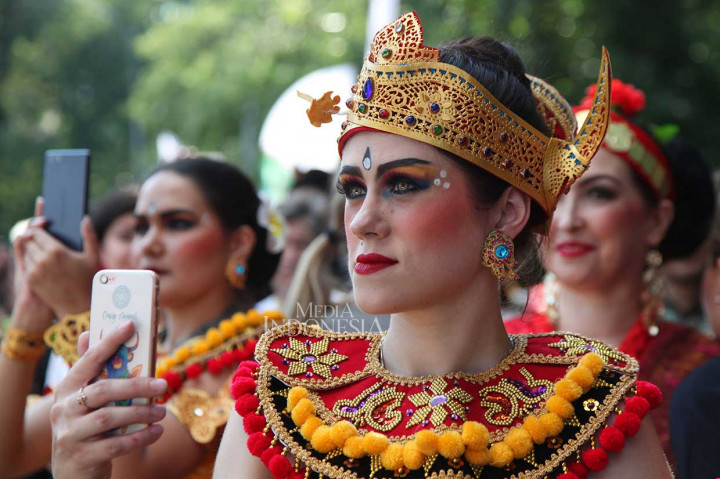 Warga Rusia yang menjadi pengisi acara dan mengenakan pakaian tradisional Indonesi mengambil gambar pertunjukan menggunakan telepon seluler.