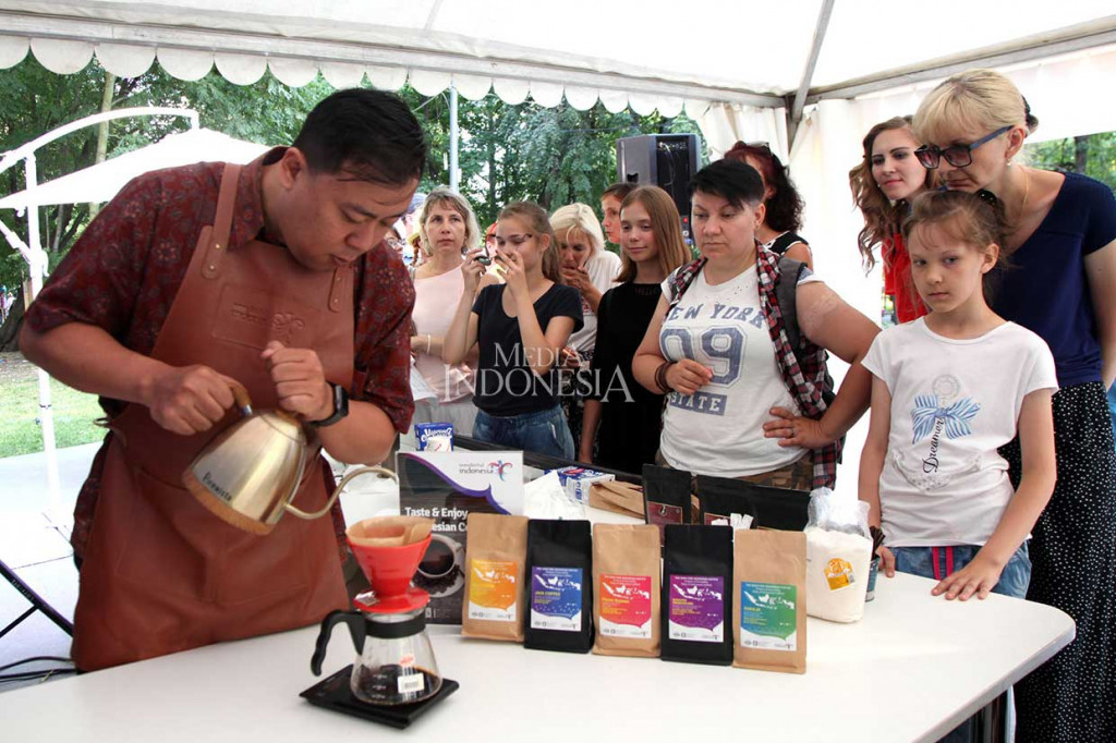 Pengunjung memperhatikan pembuatan kopi di salah satu stand yang menjual berbagai jenis kopi asli Indonesia.