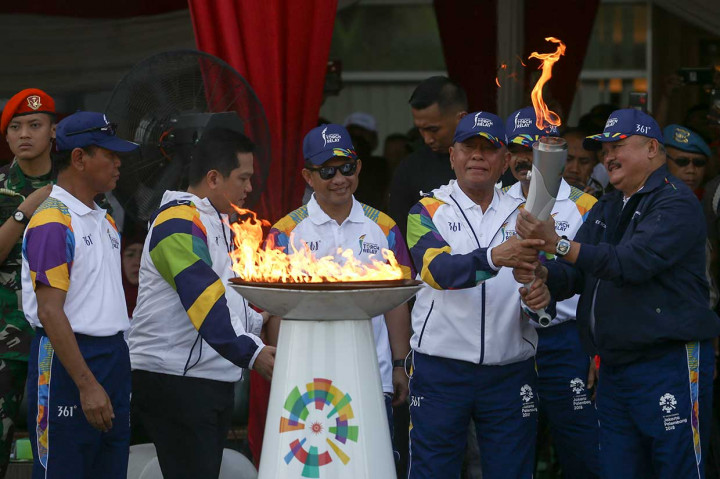 Gubernur Sumsel Alex Noerdin didampingi mantan pebulu tangkis nasional Ivana Lie menerima penyerahan obor dari Menteri Pertahanan Ryamizard Ryacudu di Plaza Stadion Gelora Sriwijaya Jakabaring. Hadir pula, Panglima TNI Marsekal Hadi Tjahjanto, Kapolri Jenderal Tito Karnavian, Ketua Komite Olimpiade Indonesia Erick Thohir dan Wakil KOI Muddai Madang.