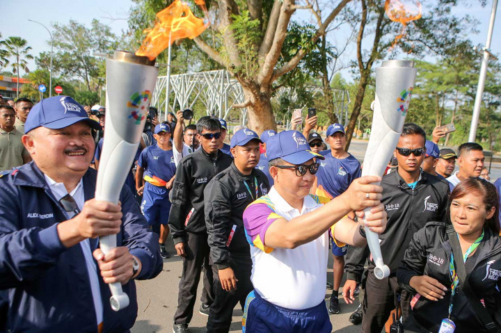 Alex kemudian berlari sekitar 50 meter didampingi Ivana Lie kemudian menyerahkan obor ke Kapolri Jenderal Tito Karnavian.