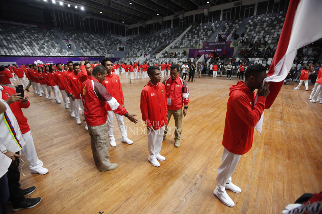 Para atlet dan ofisial melakukan ritual mencium bendera merah putih ketika acara Pengukuhan Kontingen Asian Games 2018 ddi Istora Gelora Bung Karno, Senayan, Jakarta.
