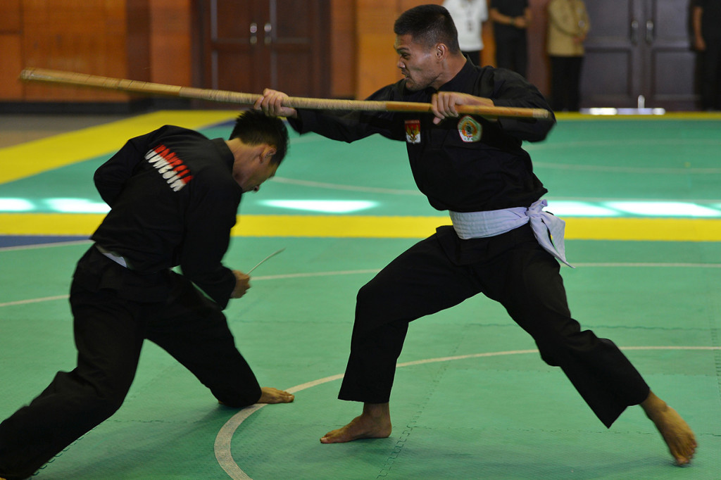Atlet pelatnas pencak silat memperagakan jurus saat kunjungan Presiden Joko Widodo di Padepokan Pencak Silat TMII, Jakarta.