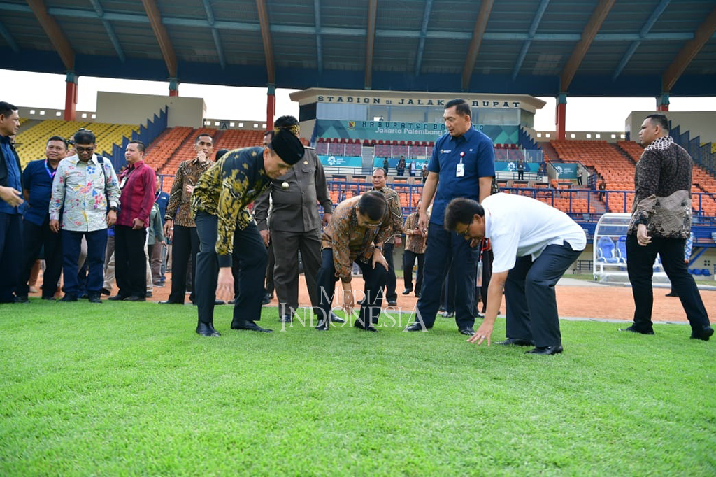 JK juga sempat turun untuk meninjau rumput lapangan sepak bola stadion. 