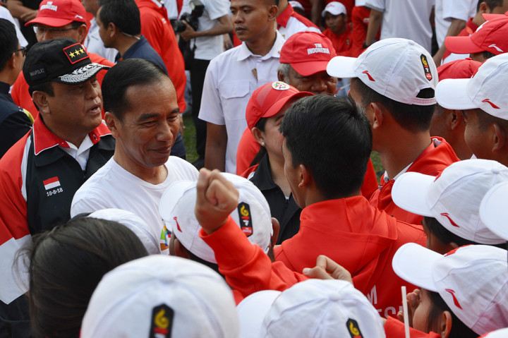 Presiden Joko Widodo (kedua kiri) didampingi CdM kontingen Indonesia, Komjen Pol Syafruddin (kiri) menyalami atlet dan ofisial seusai memimpin upacara pelepasan kontingen Asian Games 2018 di halaman tengah Kompleks Istana, Jakarta.