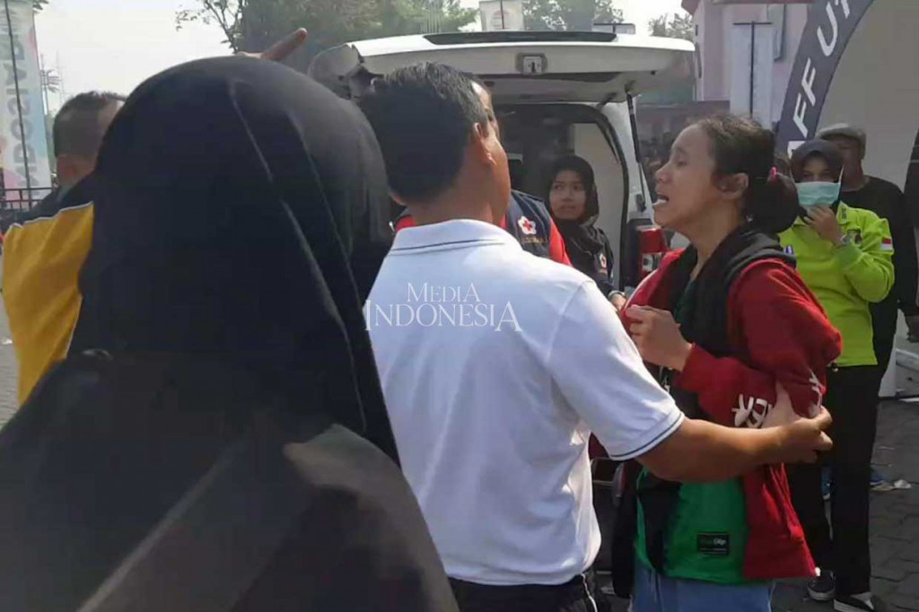 Seorang penonton putri, Evi Oktavia, 20, histeris setelah mengetahui tiket sudah habis. Padahal dia juga sudah mengantre sejak Jumat malam. Sejumlah aparat berusaha menenangkan suporter yang histeris ini.