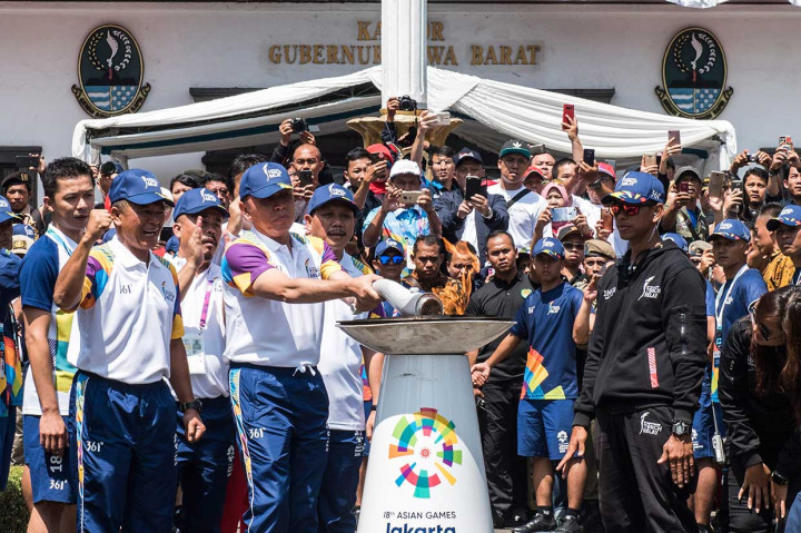 Penjabat Gubernur Jawa Barat M Iriawan (tengah) didampingi Pangdam III Siliwangi Mayjen Besar Harto Karyawan (kedua kiri) dan mantan pebulu tangkis Taufik Hidayat (kiri) menyalakan mini kaldron saat prosesi Torch Relay Asian Games 2018 di Gedung Sate.