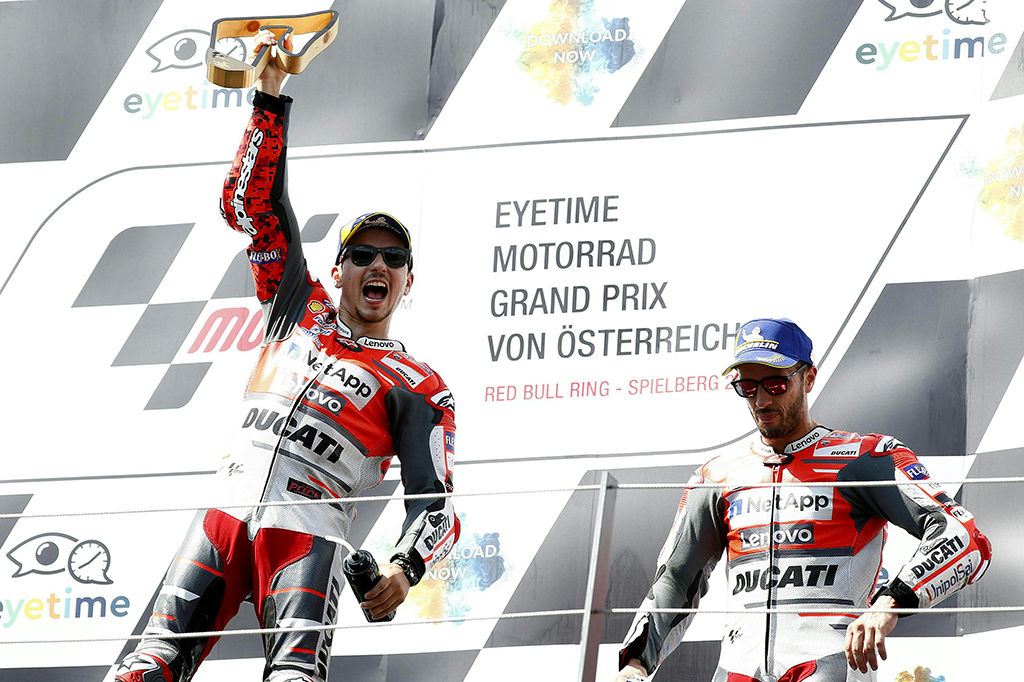 Pembalap tim Ducati Team, Jorge Lorenzo merayakan kemenangan sambil memegang piala di podium Grand Prix MotoGP Austria di Red Bull Ring di Spielberg. Afp Photo/Erwin Scheriau