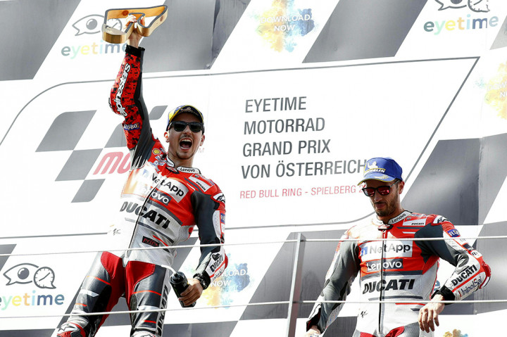 Pembalap tim Ducati Team, Jorge Lorenzo merayakan kemenangan sambil memegang piala di podium Grand Prix MotoGP Austria di Red Bull Ring di Spielberg. Afp Photo/Erwin Scheriau