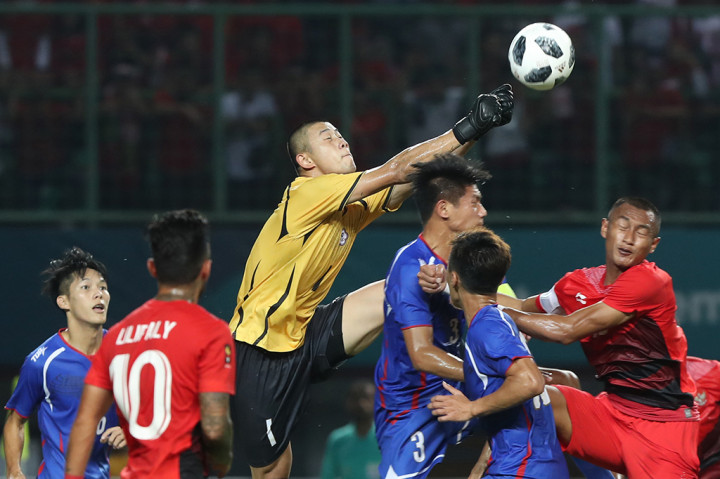 Penjaga gawang Taiwan Wenchieh Pan (tengah) berhasil menggagalkan serangan pemain Indonesia pada pertandingan Grup A Asian Games ke-18 di Stadion Patriot, Bekasi. INASGOC/Charlie