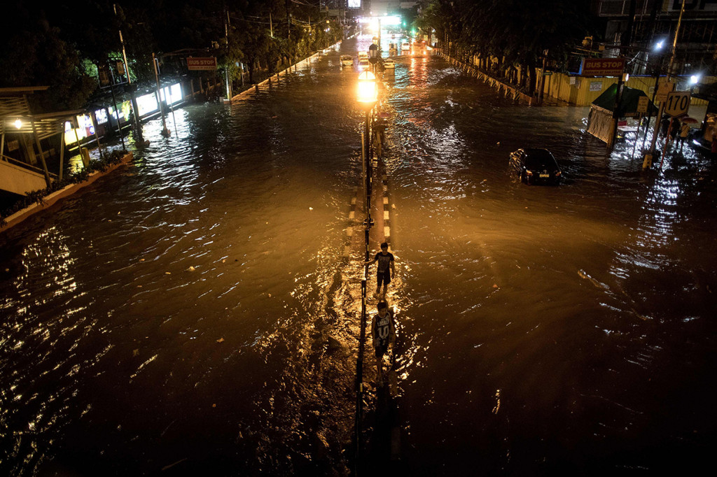 Air di beberapa wilayah meluap hingga ke ketinggian sekitar 70 sentimeter dan membuat jalan-jalan di kota Manila dan sekitarnya tak dapat dilalui kendaraan. Jasa transportasi kereta api dihentikan dan sejumlah sekolah di Manila ditutup. Afp Photo/Noel Celis