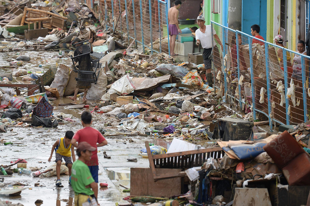 Sejumlah warga mulai kembali ke rumah-rumah untuk mengumpulkan benda-benda berharga dari rumah mereka usai terendam banjir. Afp Photo/Ted Aljibe