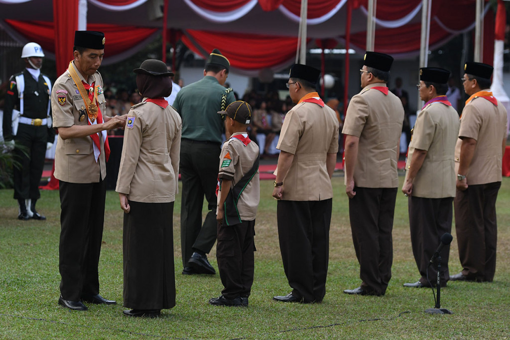 Presiden Joko Widodo menyerahkan penghargaan saat upacara peringatan Hari Ulang Tahun (HUT) ke-57 Pramuka di Bumi Perkemahan Cibubur, Jakarta.