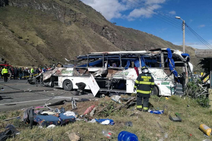 Petugas pemadam kebakaran mengevakuasi korban kecelakaan sebuah bus menabrak kendaraan lain, di jalan antara Pifo dan Papallacta, 30 kilometer timur Quito, Selasa, 14 Agustus 2018 waktu setempat.