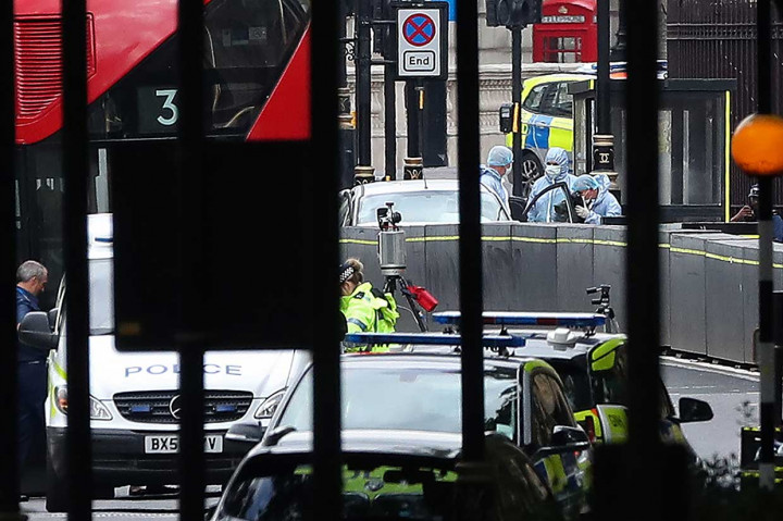 Petugas kepolisian melakukan olah tempat kejadian perkara (TKP) sebuah mobil yang menabrak pembatas jalan di luar Gedung Parlemen Inggris di London, Selasa, 14 Agustus 2018.