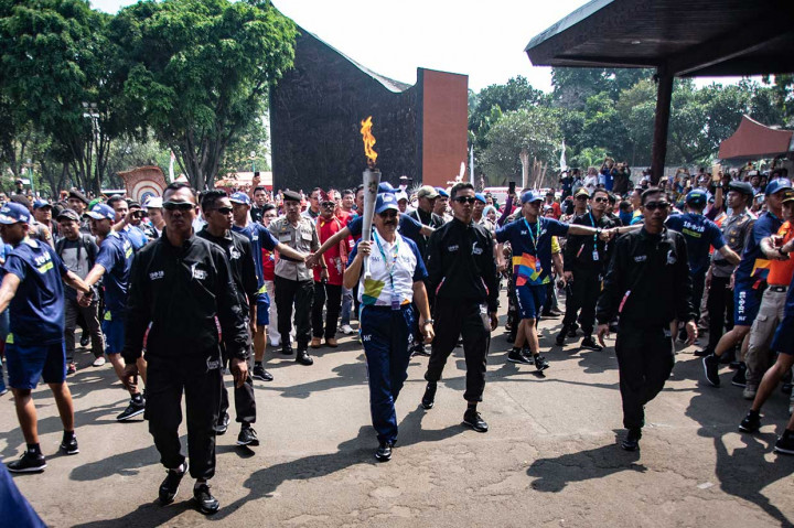 Direktur Utama Taman Mini Indonesia Indah (TMII) Mayjen TNI (Purn) A Tanribali Lamo (tengah) membawa obor Asian Games 2018 saat prosesi Torch Relay Asian Games 2018 memasuki kawasan TMII, Jakarta Timur.