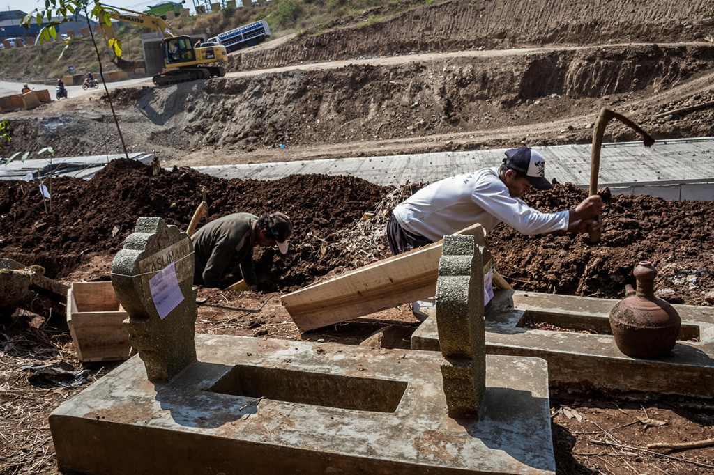 Pekerja menggali makam saat proses relokasi di Tempat Pemakaman Umum (TPU) Klampisan, Desa Purwoyoso, Ngaliyan, Semarang, Jawa Tengah.