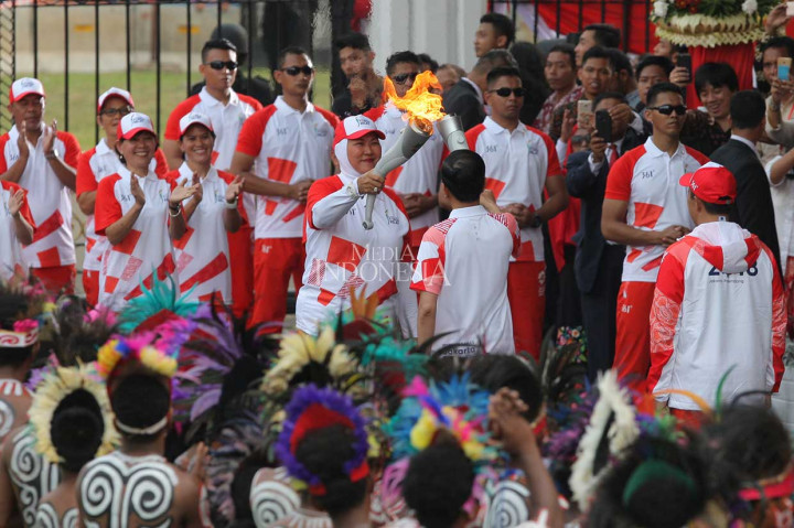 Presiden Joko Widodo didampingi Menteri Pemuda dan Olahraga Imam Nahrawi berlari kecil menyambut obor Asian Games yang telah masuk di pintu gerbang Istana Merdeka, Jakarta. Presiden menerima api obor tersebut dari atlet bulu tangkis legendaris Verawaty Fajrin.