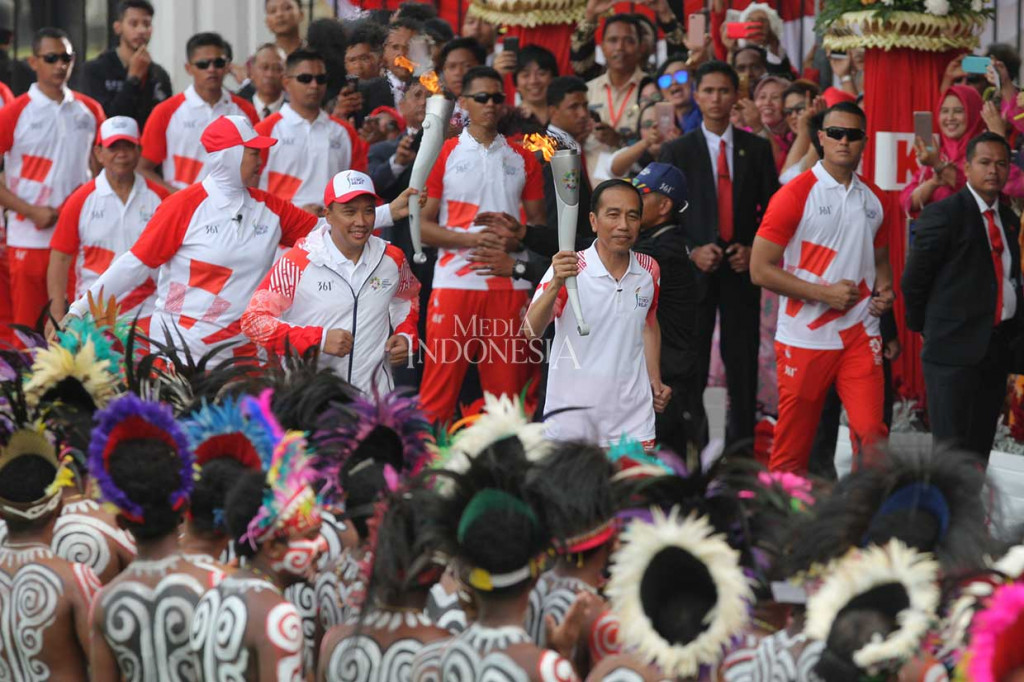 Bersama Menteri Pemuda dan Olahraga Imam Nahrawi dan peserta kirab, Jokowi berlari kecil melakukan kirab obor Asian Games 2018, di halaman Istana Negara, Jakarta, Jumat.