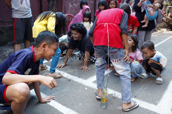 Anak-anak mengikuti lomba memasukkan paku ke dalam botol di Jalan Menteng Jaya, Jakarta Pusat, Jumat. MI/Bary Fathahilah