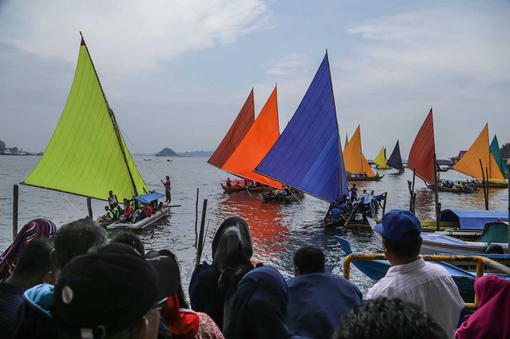 Warga menyaksikan lomba sampan layar di Pelabuhan Belakang Padang, Batam, Kepulauan Riau. Antara Foto/MN Kanwa
