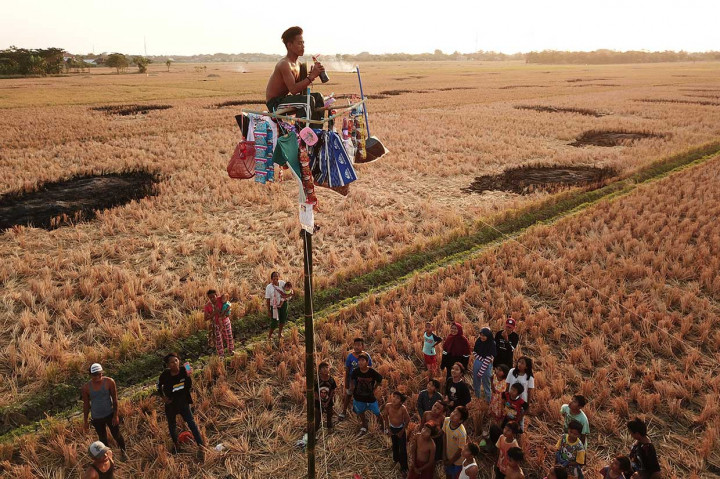Warga mengikuti lomba panjat pinang di kampung nelayan Pabean udik, Indramayu, Jabar. Antara Foto/Dedhez Anggara