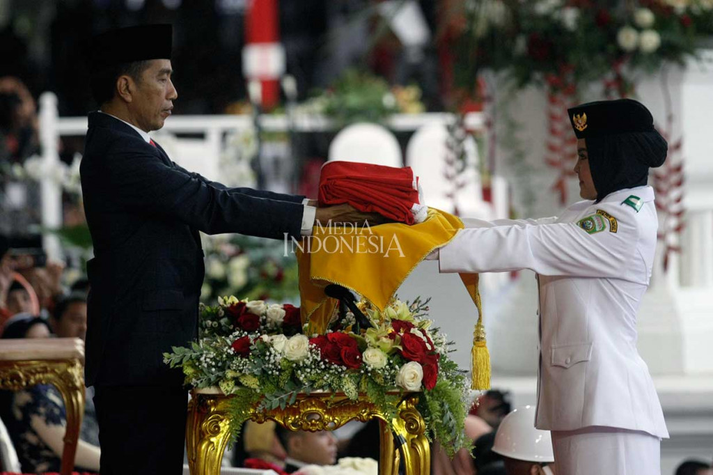 Presiden Joko widodo mengambil Bendera Merah Putih dari Anggota Paskibraka Zanati Tahta Umahati dalam Upacara Penurunan Bendera Merah Putih pada HUT ke-73 RI di Istana Merdeka, Jakarta.