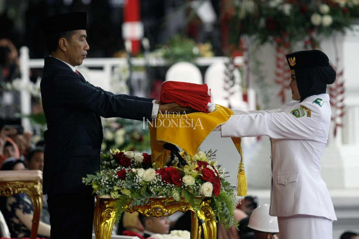 Presiden Joko widodo mengambil Bendera Merah Putih dari Anggota Paskibraka Zanati Tahta Umahati dalam Upacara Penurunan Bendera Merah Putih pada HUT ke-73 RI di Istana Merdeka, Jakarta.