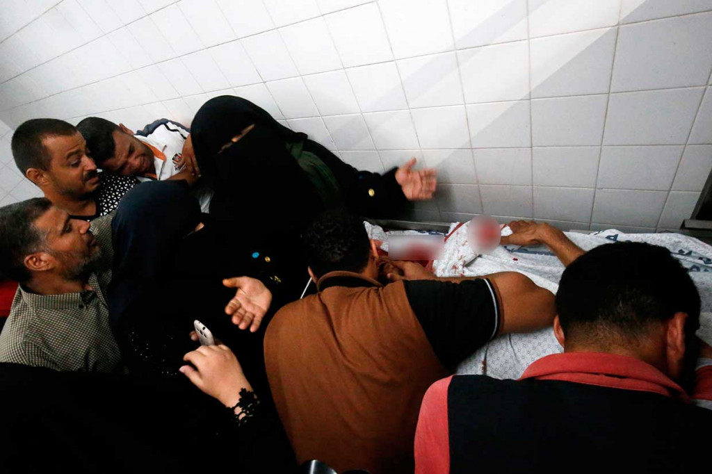 Kerabat dan tetangga berduka atas tewasnya Sadi Moamer yang disemayamkan di kamar jenazah sebuah rumah sakit di dekat Rafah, Jumat, 17 Agustus 2018.