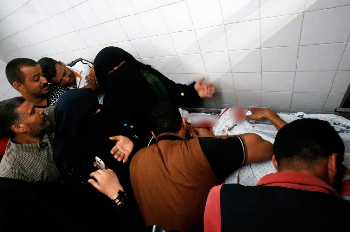 Kerabat dan tetangga berduka atas tewasnya Sadi Moamer yang disemayamkan di kamar jenazah sebuah rumah sakit di dekat Rafah, Jumat, 17 Agustus 2018.