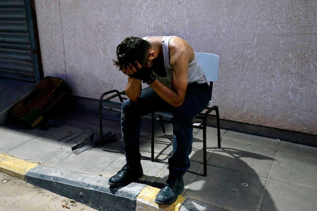 Seorang pria meratapi kematian sahabatnya Sadi Moamer di luar sebuah rumah sakit di dekat Rafah.