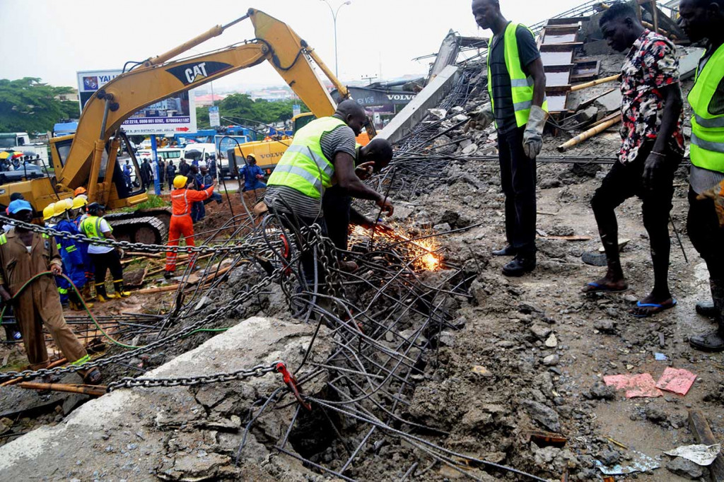 Tim SAR tengah berusaha keras menyingkirkan beton dengan menggunakan las untuk mengevakuasi orang yang diduga terperangkap reruntuhan bangunan di Abuja, Nigeria, Jumat, 17 Agustus waktu setempat. Petugas juga dibantu alat berat.
