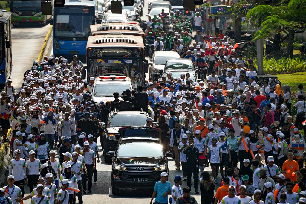 Dari kawasan Monas ribuan warga antusias mengikuti kirab obor yang melintasi sepanjang Jalan MH Thamrin-Jenderal Sudirman. AFP Photo/Bay Ismoyo