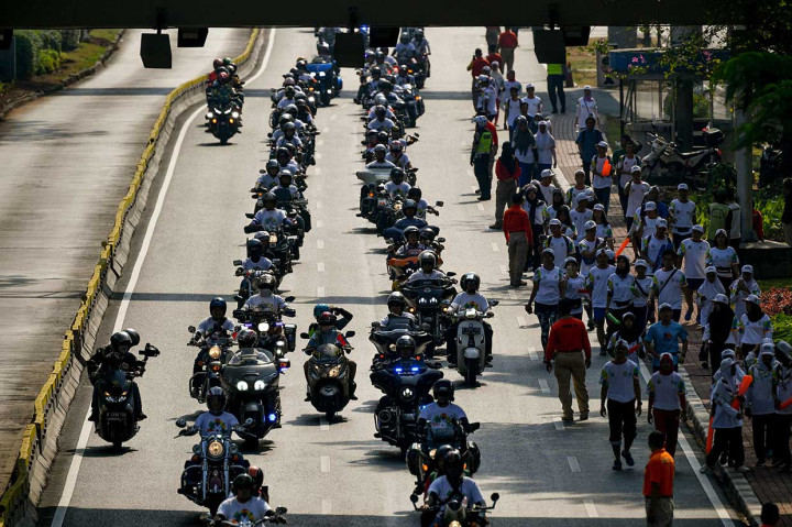 Kirab obor dari Monas menuju GBK juga dikawal oleh ratusan motor gede (moge) dari komunitas Motor Besar Indonesia (MBI). AFP Photo/Bay Ismoyo