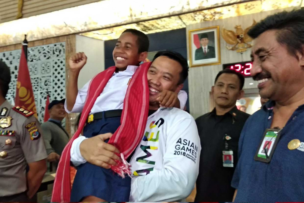 Tiba di Gedung Kemenpora, Yohanis Gama Marschal Lau disambut langsung oleh Menpora Imam Nahrawi. Joni yang datang dengan mengenakan seragam sekolah SMP dan berkalung selendang tenun merah khas NTT sempat digendong oleh Menpora.