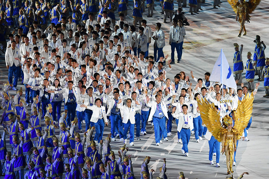Momen kontingen Korea Utara dan Korea Selatan yang saling bergandengan tangan juga tak kalah mencuri perhatian. Afp Photo/Adek Berry
