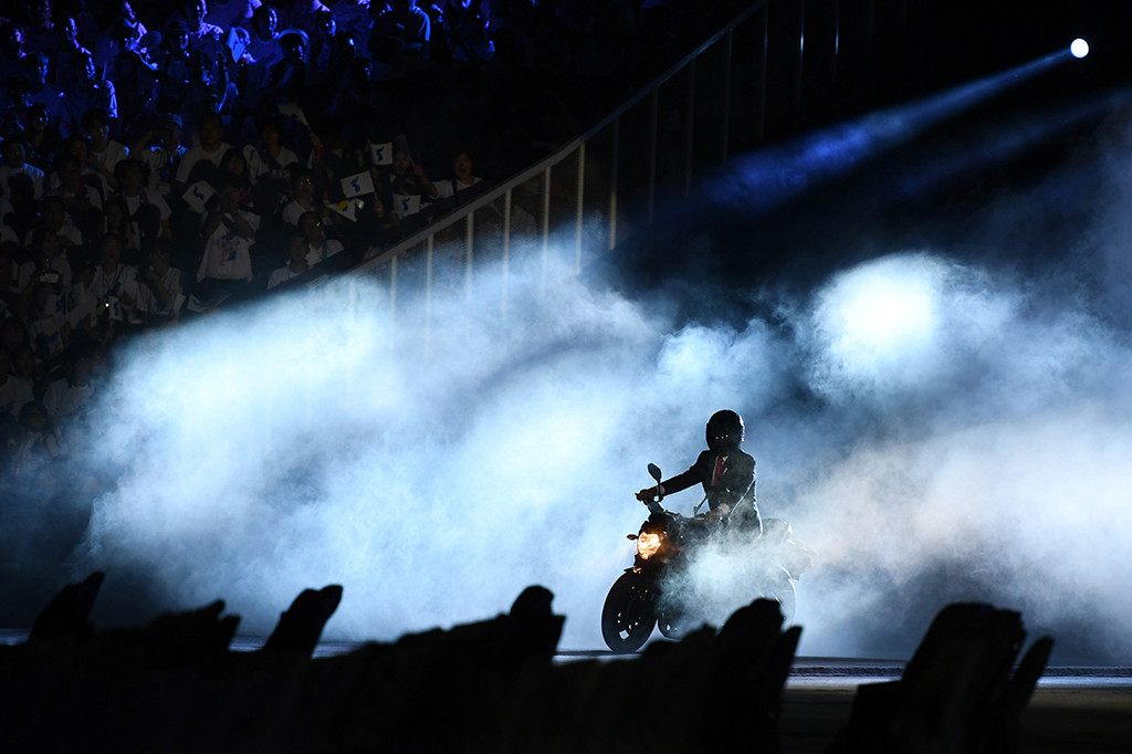 Presiden Joko Widodo membuat kejutan di pembukaan Asian Games 2018. 'Jokowi' naik moge hitam ke lokasi pembukaan. Afp Photo/Jewel Samad