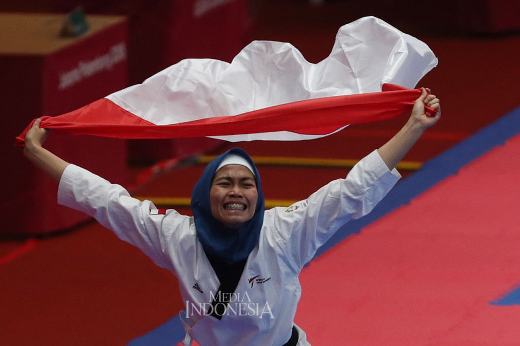 Atlet Taekwondo Indonesia Defia Rosmaniar melakukan selebrasi kemenangan setelah mengalahkan atlet taekwondo Iran, Marjan Salahshouri pada nomor poomsae individu putri di Plenary Hall Jakarta Convention Centre. MI/Ramdani