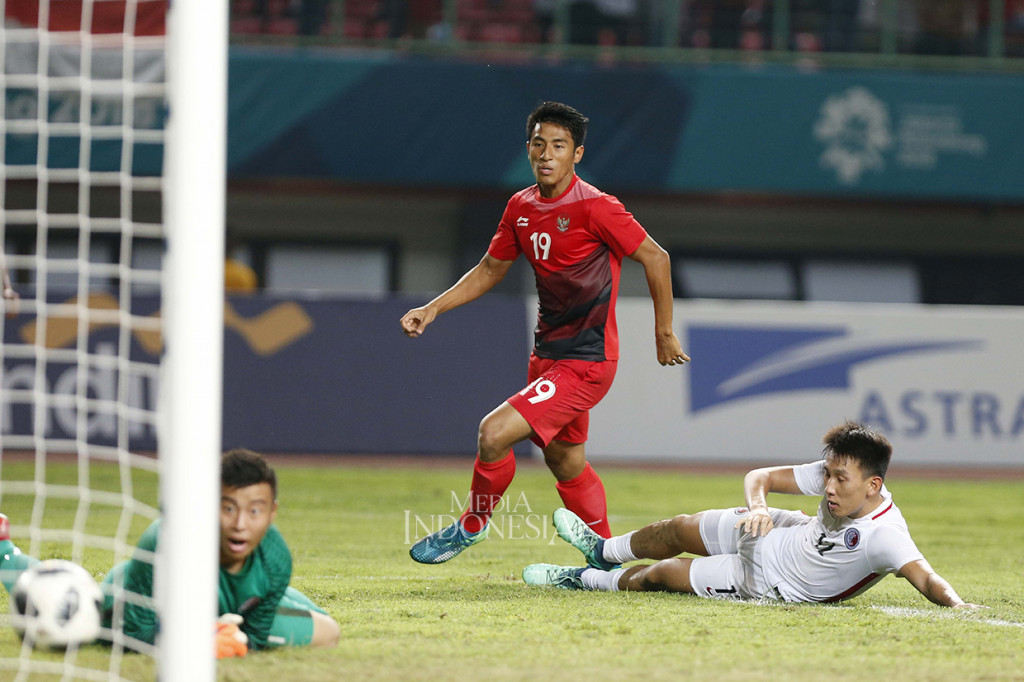 Pesepak bola Indonesia Hanif Abdurrauf melesakkan gol ke gawang Hong Kong yang dijaga Ho Chun Yuen dengan dibayangi pemain Chun Ming Wu pada pertandingan kualifikasi Grup A Asian Games 2018 di Stadion Patriot Candrabhaga, Bekasi.
